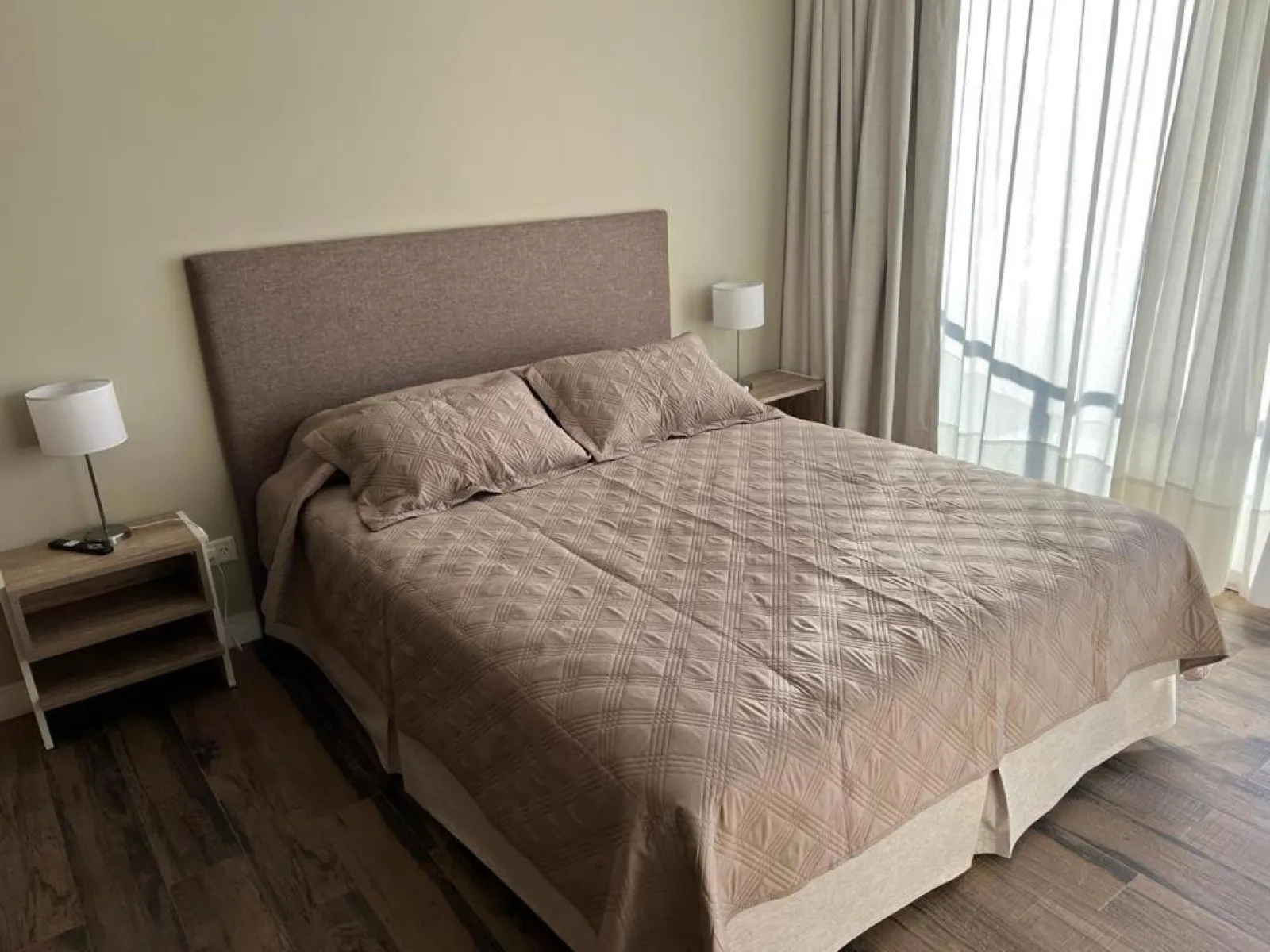 Cama tendida junto al ventanal