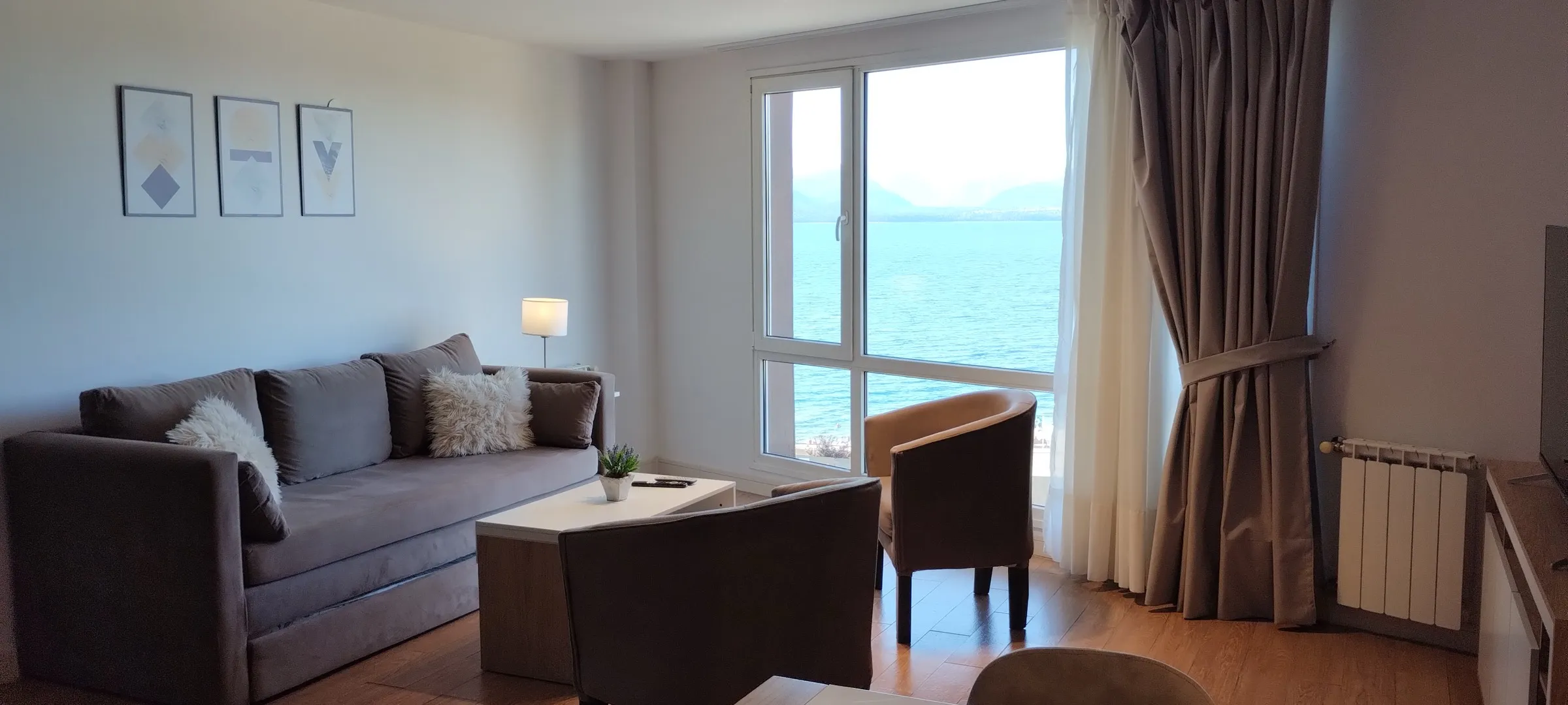 Living con ventanal abierto al lago Nahuel Huapi — foto real del departamento